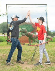 Dad son high five at archery range