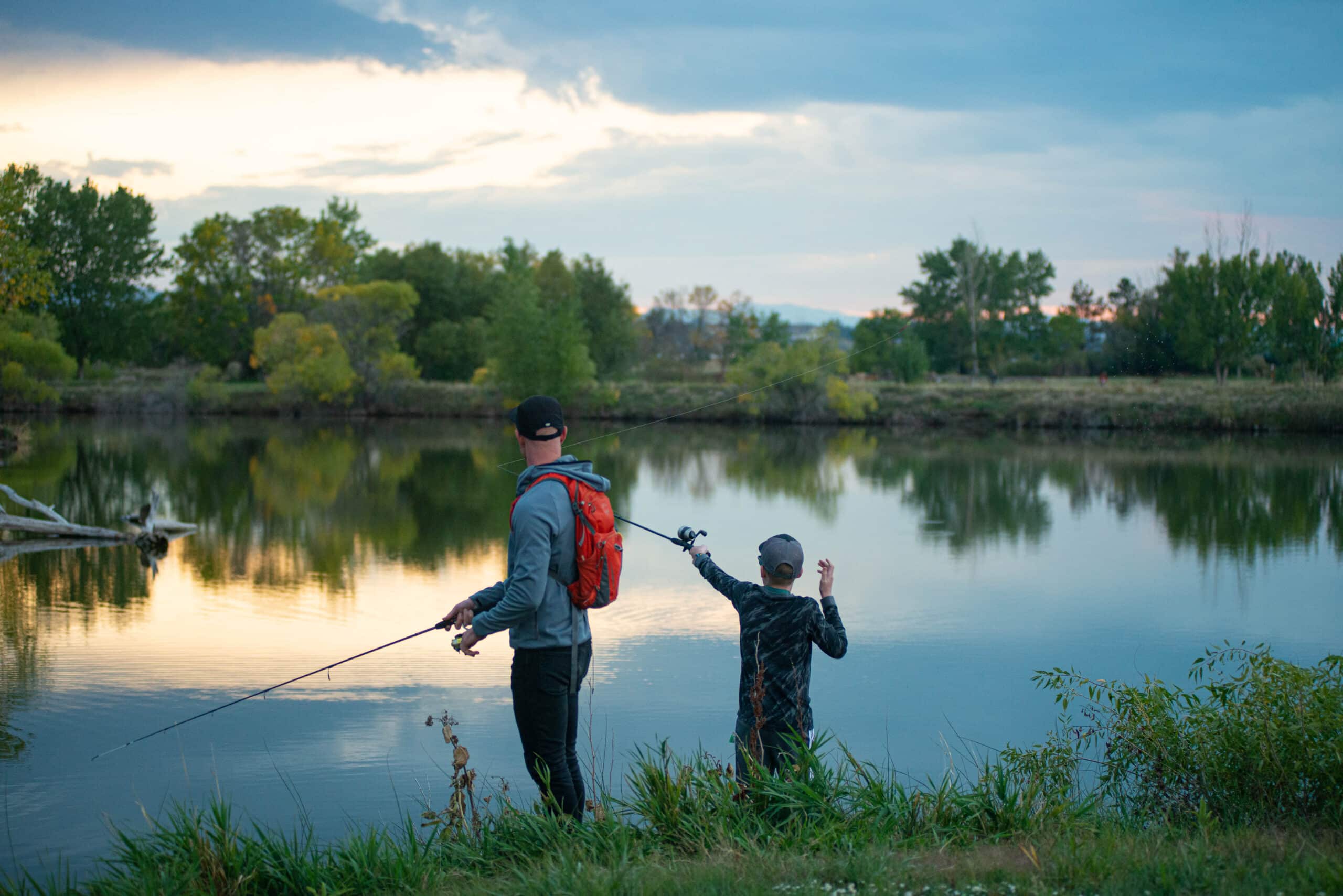 a father and son fishing together at dusk