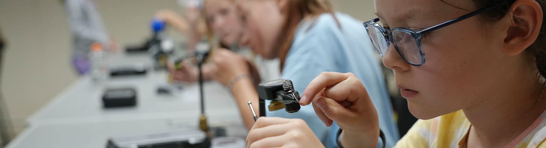 Summer camp kids in fly tying class