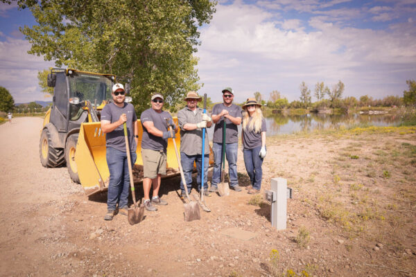 Employees from Civitas filling in dirt near newly installed electrical box